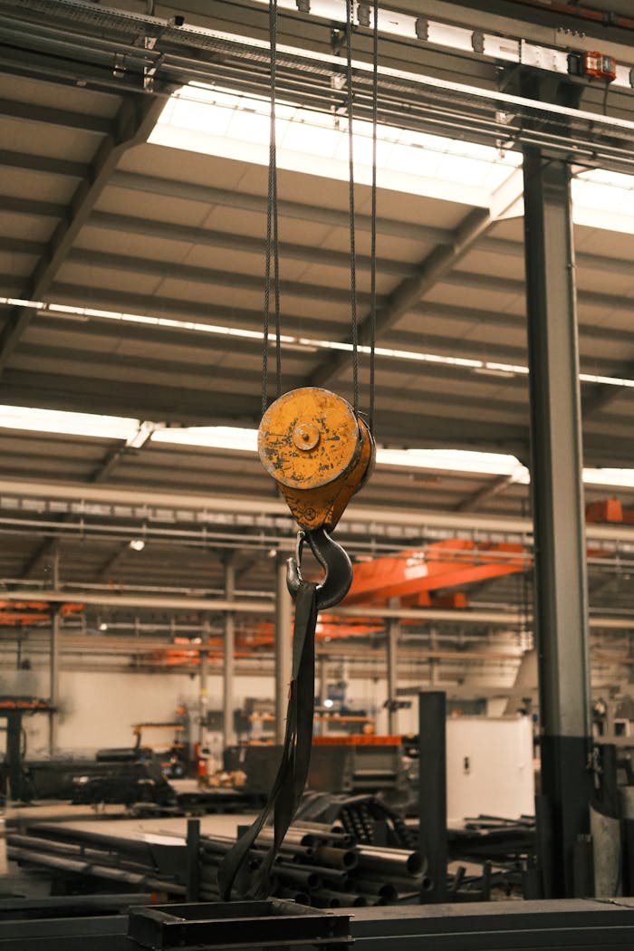 Close-up of an industrial crane hook in a factory setting. Ideal for technology and manufacturing themes.