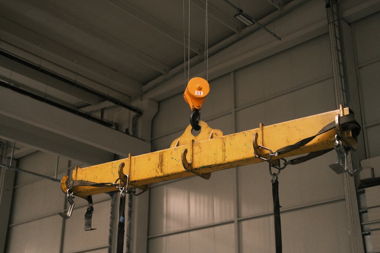 Close-up of a yellow industrial crane used in manufacturing, highlighting strength and machinery.
